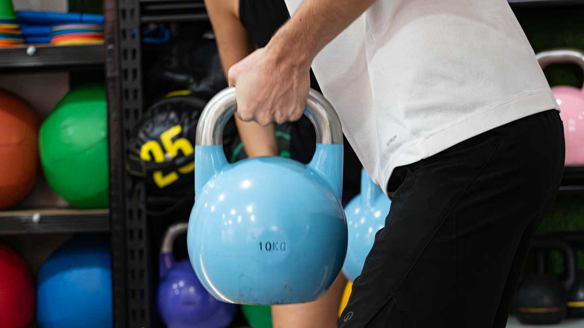 Un atleta con una pesa kettlebell en su mano.